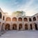 Historic stone courtyard with arched walkways and scattered artifacts